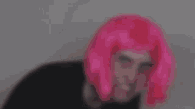 the man is wearing a pink wig and a black shirt .