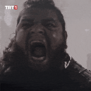 a man with a beard is screaming in front of a trt 1 logo