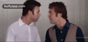 two men are standing next to each other and looking at each other with their eyes closed .