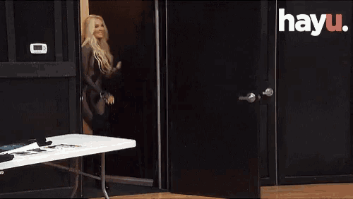 a woman in a very revealing outfit is standing in a doorway with hayu written on the bottom