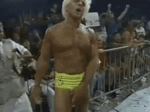 a shirtless man is standing in front of a crowd .