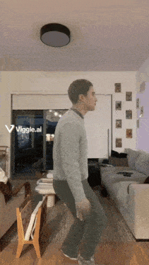 a man is dancing in a living room with a viggle.ai icon on the bottom right