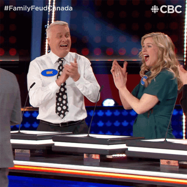 a man and a woman are applauding during a family feud game