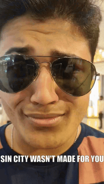 a man wearing sunglasses with sin city was n't made for you written below him
