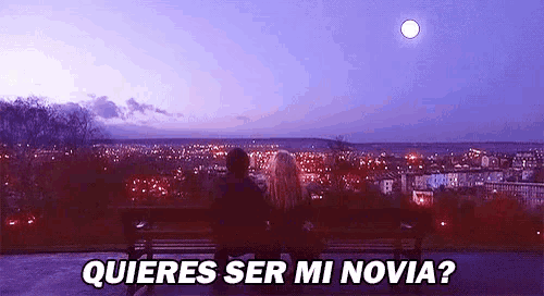a man and a woman are sitting on a bench looking at a full moon over a city .