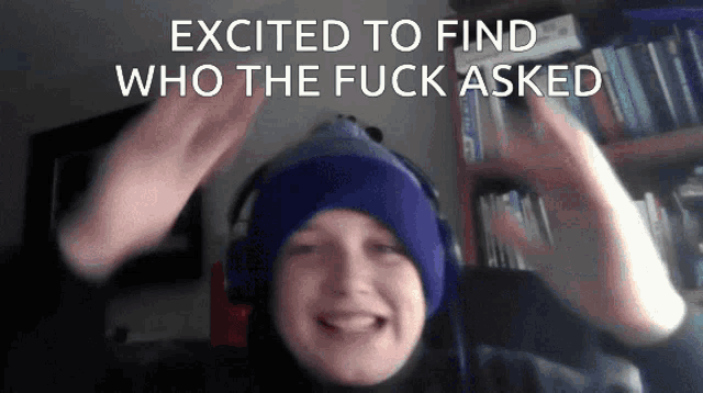 a boy wearing headphones and a blue beanie is excited to find who the fuck asked