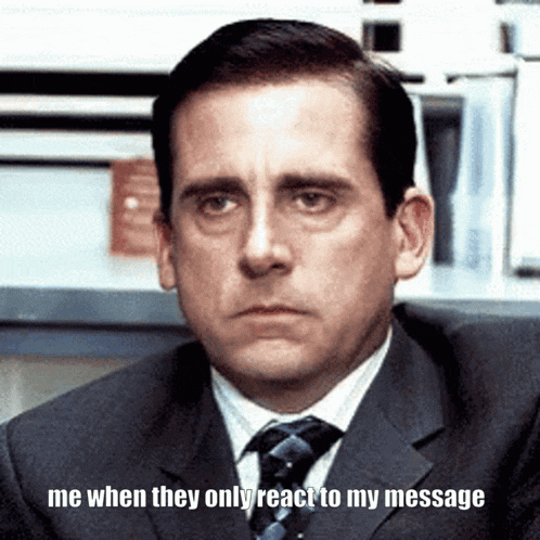 a man in a suit and tie is sitting in front of a sign that says me when they only react to my message
