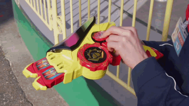 a person is holding a toy that has a red and yellow item on it