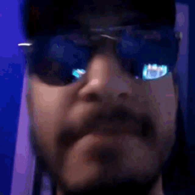 a man with a beard wearing sunglasses and a baseball cap