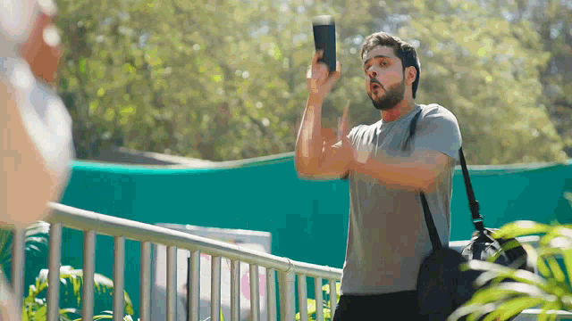 a man with a beard is holding a cell phone