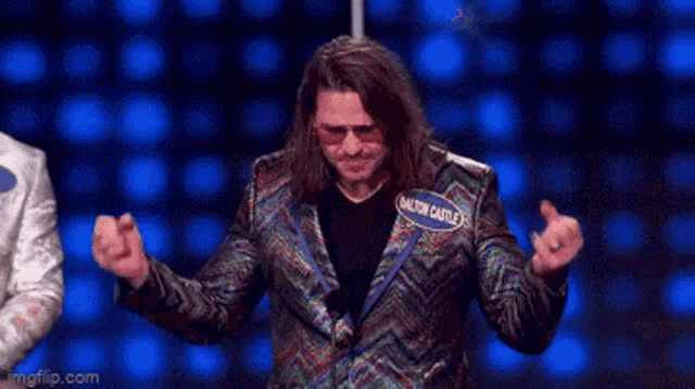 a man in a colorful suit with a name tag that says lion castle