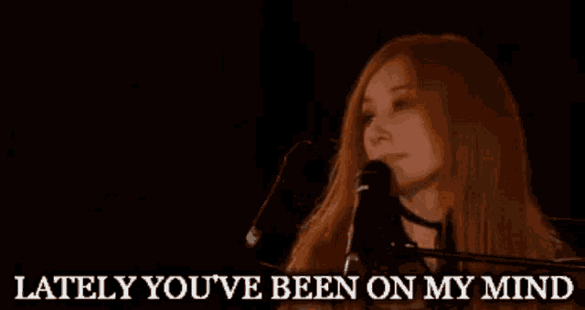 a woman singing into a microphone with the words " lately you 've been on my mind " below her