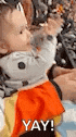 a baby is wearing a cat costume and holding a puppet .