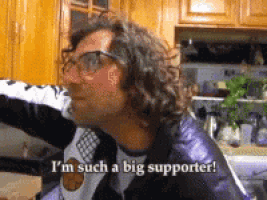 a man with glasses and a purple jacket says i 'm such a big supporter
