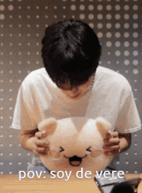 a man in a white shirt is holding a stuffed animal with the words pov soy de vere on the bottom