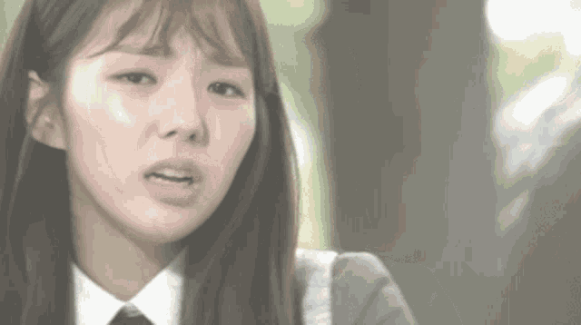 a close up of a woman 's face with a sad look on her face