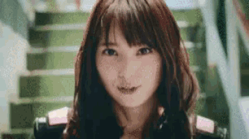 a close up of a woman 's face in front of stairs .