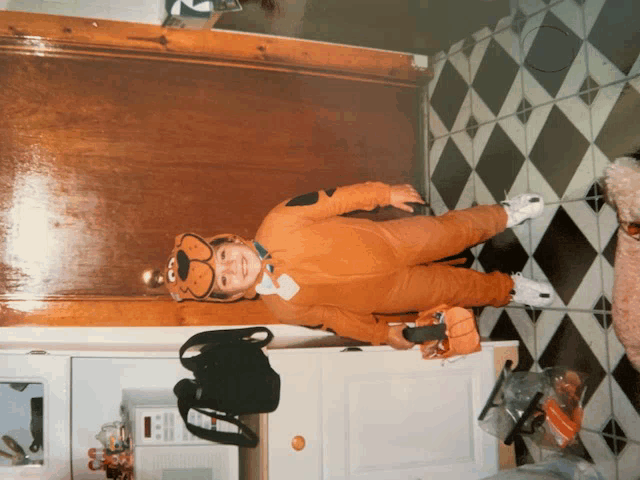 a boy in a scooby doo costume is standing in a kitchen