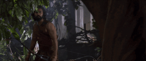a man with a beard is holding a bow and arrows