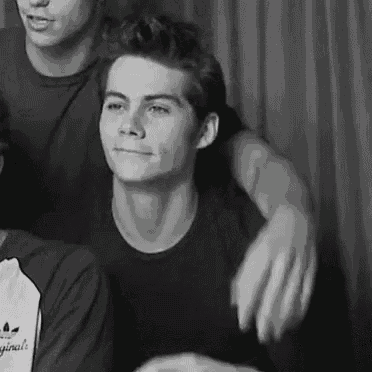 a black and white photo of a young man in a black t-shirt .