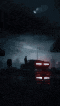 a blurry picture of a gas station at night with a cloudy sky and a red truck in the foreground .