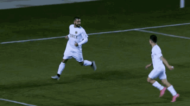 two soccer players one with the number 2 on his shirt