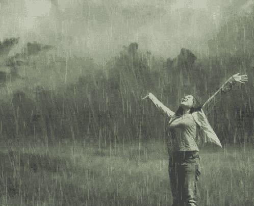 a woman is standing in the rain with her arms outstretched and bom dia chuvoso written above her