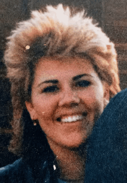 a close up of a woman 's face smiling for the camera