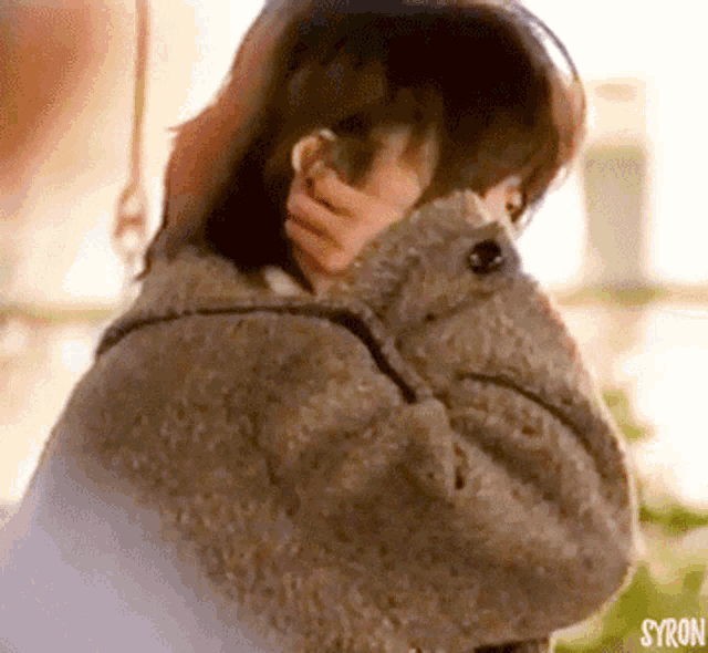 a close up of a person covering their face with a blanket with the word syron on the bottom