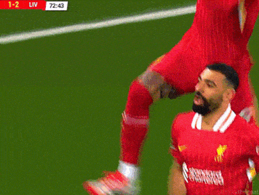 a soccer player kneeling on the field with the score 1-2 liv at the top of the screen