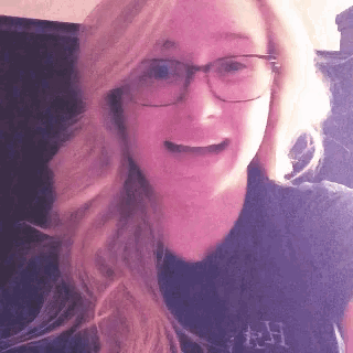 a woman wearing glasses and a shirt that says rh on it