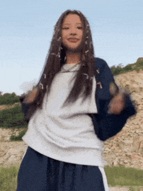 a girl with dreadlocks is dancing in front of a rock formation