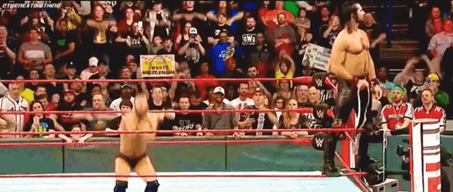a wrestling match is going on in front of a crowd with a sign that says wwe