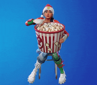 a woman is sitting on a stool holding a large bucket of popcorn .