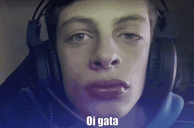 a close up of a person wearing headphones with the words oi gata written on the bottom