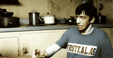 a man wearing a blue shirt that says first.a.l.a.s.
