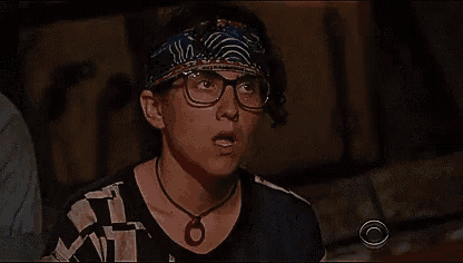 a woman wearing glasses and a bandana looks surprised