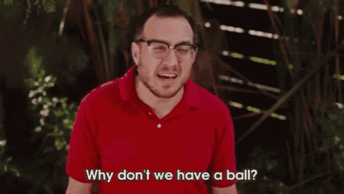 a man in a red shirt is holding a baseball and a glove and saying why don 't we have a ball
