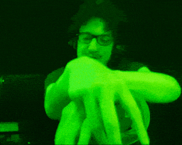 a man wearing glasses and headphones is glowing green