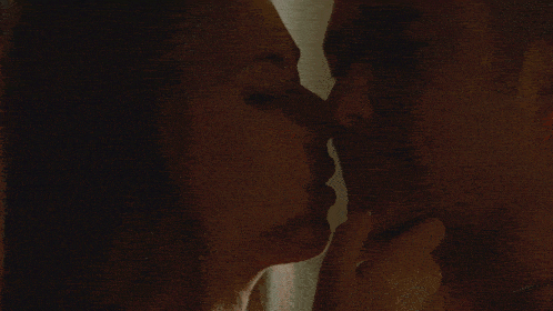 a man and woman are kissing in the dark