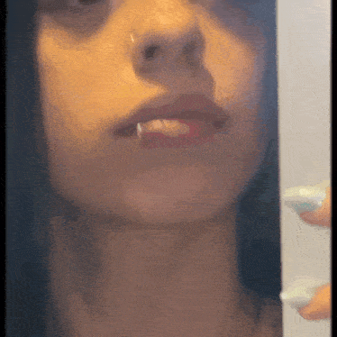 a close up of a woman 's face with a nose ring and a piercing in her lip .