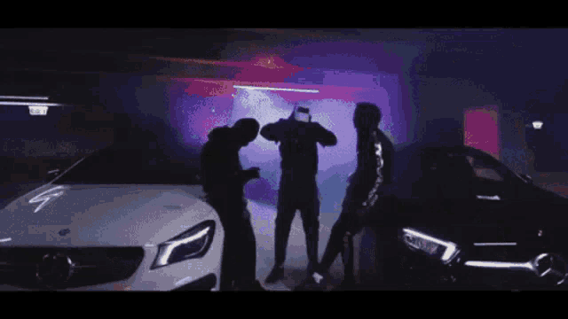 a group of men are standing next to each other in front of a white car .