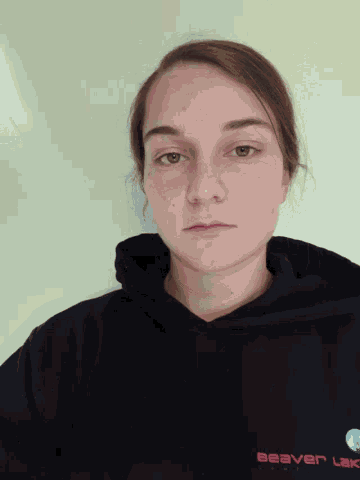 a woman wearing a black sweatshirt with the word beaver on it
