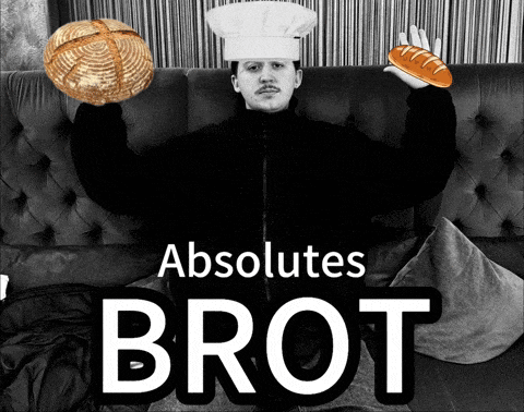 a man in a chef 's hat holds a loaf of bread and a loaf of bread