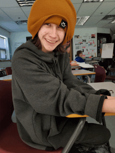 a young man wearing a beanie with a smiley face on it