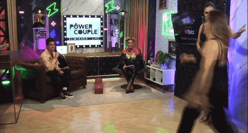a man and woman are sitting in front of a power couple sign
