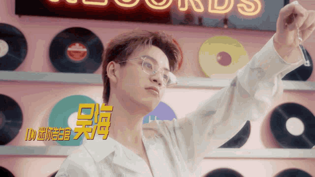 a man wearing glasses stands in front of a sign that says records