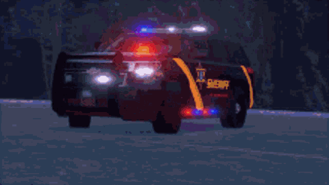 a sheriff 's car is driving down a snow covered road