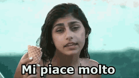 a woman in a bikini is holding an ice cream cone and saying mi piace molto .