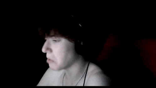 a man is wearing headphones and making a funny face .